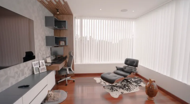 vista de una sala moderna con una silla reclinable, luz natural y persianas