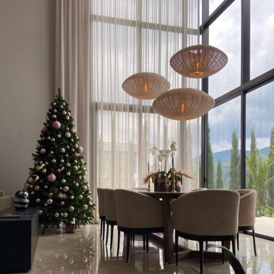 Comedor decorado en Navidad con cortinas translúcidas en ventanales altos
