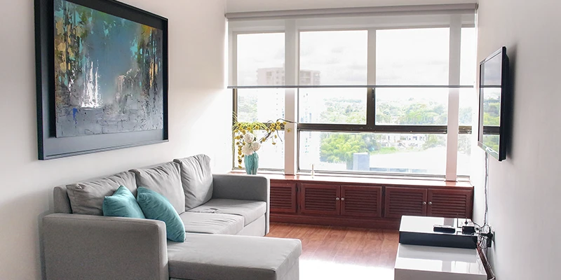 Vista de una sala moderna con cortinas enrollables y decoración contemporánea.
