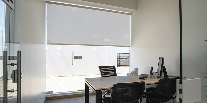 Ventana con cortinas enrollables que ofrecen privacidad.