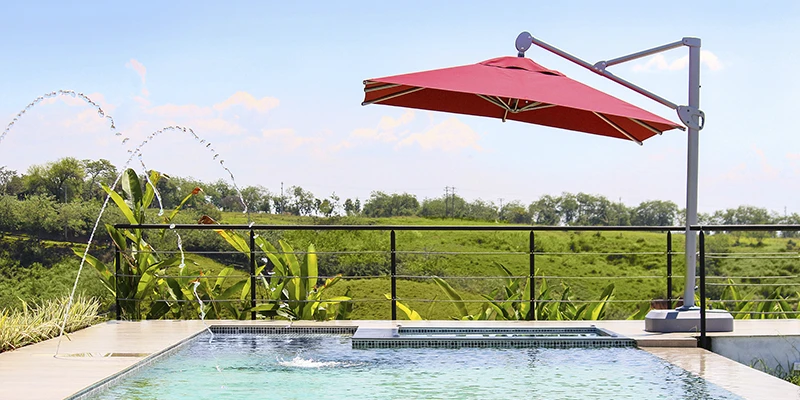 Parasol grande sobre mesa junto a la piscina