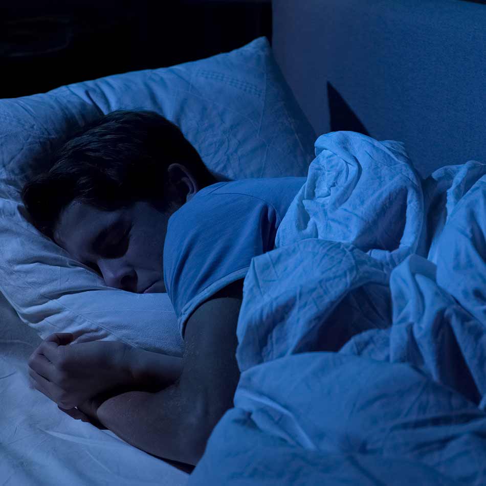 Persona durmiendo en un ambiente de total oscuridad cubierto con persianas con telas blackout Pentagrama