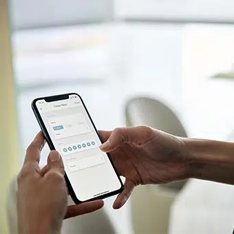 Detalle a celular con la app de Pentagrama para accionar las persianas