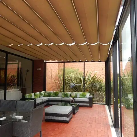 Pérgola Romana en color café cubriendo un sala semi abierta