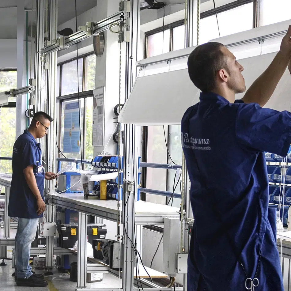 Dos operarios de Pentagrama montando un toldo en la planta de fabricación