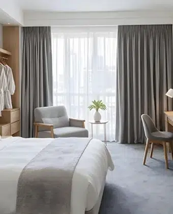 Cortinas hoteleras grises con velo blanco en una habitación de hotel con vista a la ciudad