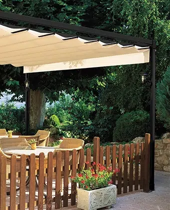 Pérgola Romana con techo retráctil en tela beige sobre un comedor de jardín